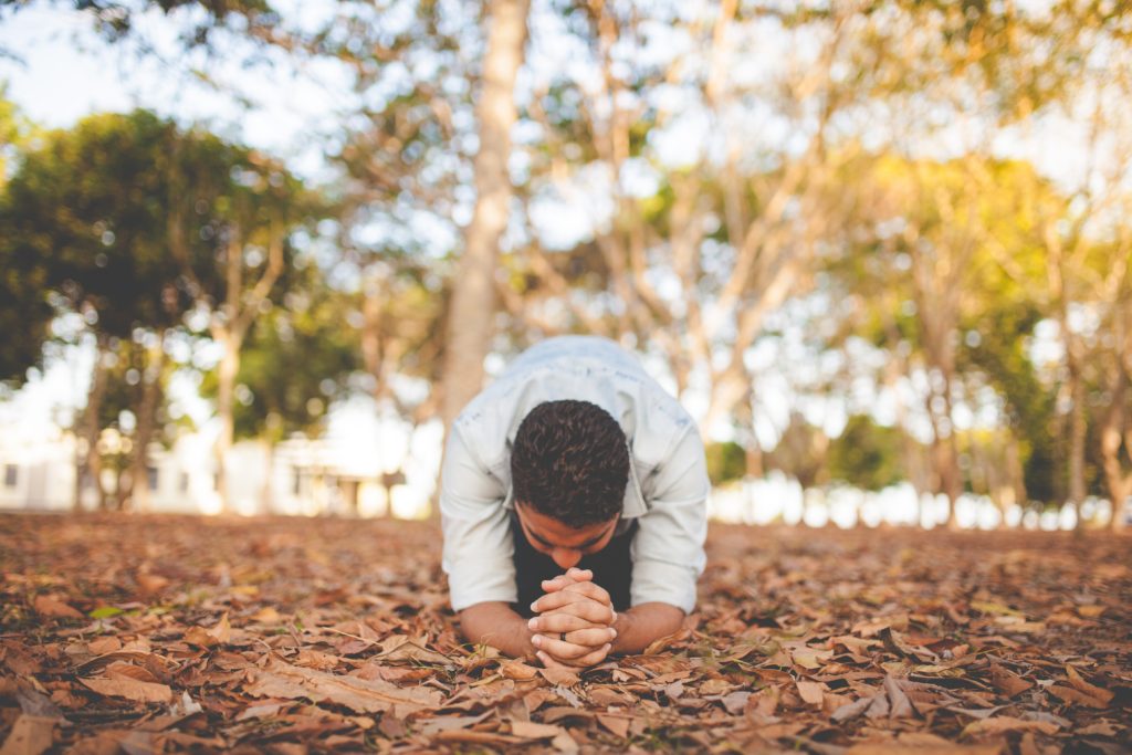 Man kneeling and praying, depicting persistence